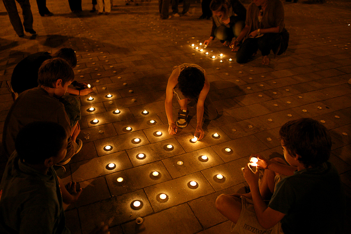 Nens encenent espelmes