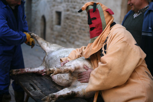 Una diablera jugant amb el porc acabat de matar