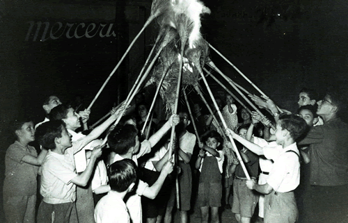 Un grup de nens donen foc a unes escombres abans d'encendre la foguera