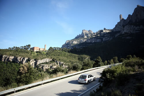 Pelegrins arribant amb cotxe, amb Sant Benet i el Cavall Bernat al fons