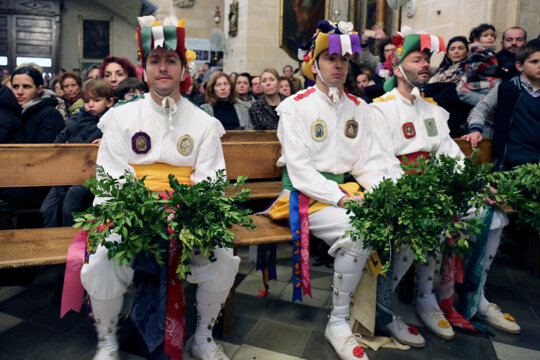 Cossiers esperant a fer el ball de l'oferta dins l'església