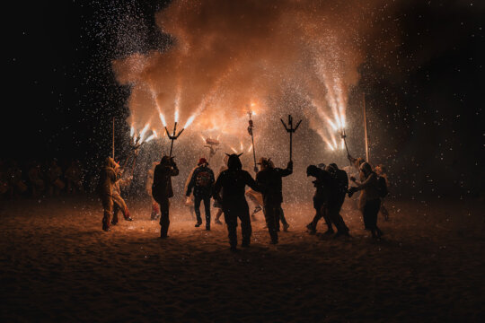 Encesa dels diables a la platja, al final del Correfoc. Bany d'un dels dracs. Foto: Biel Rovira