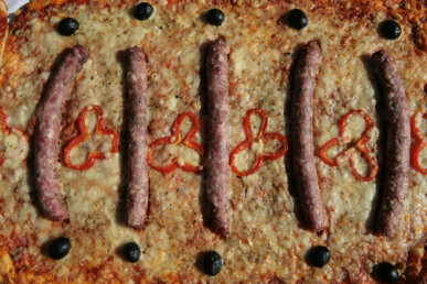 Coca amb salsitxes, pebrot i olives