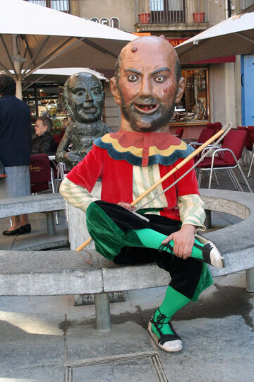En Merma assegut davant la seva escultura