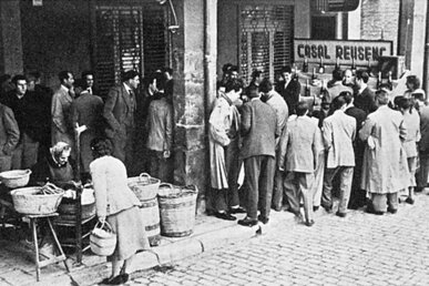 Foto antiga d'una rifa de panellets al carrer, a Reus
